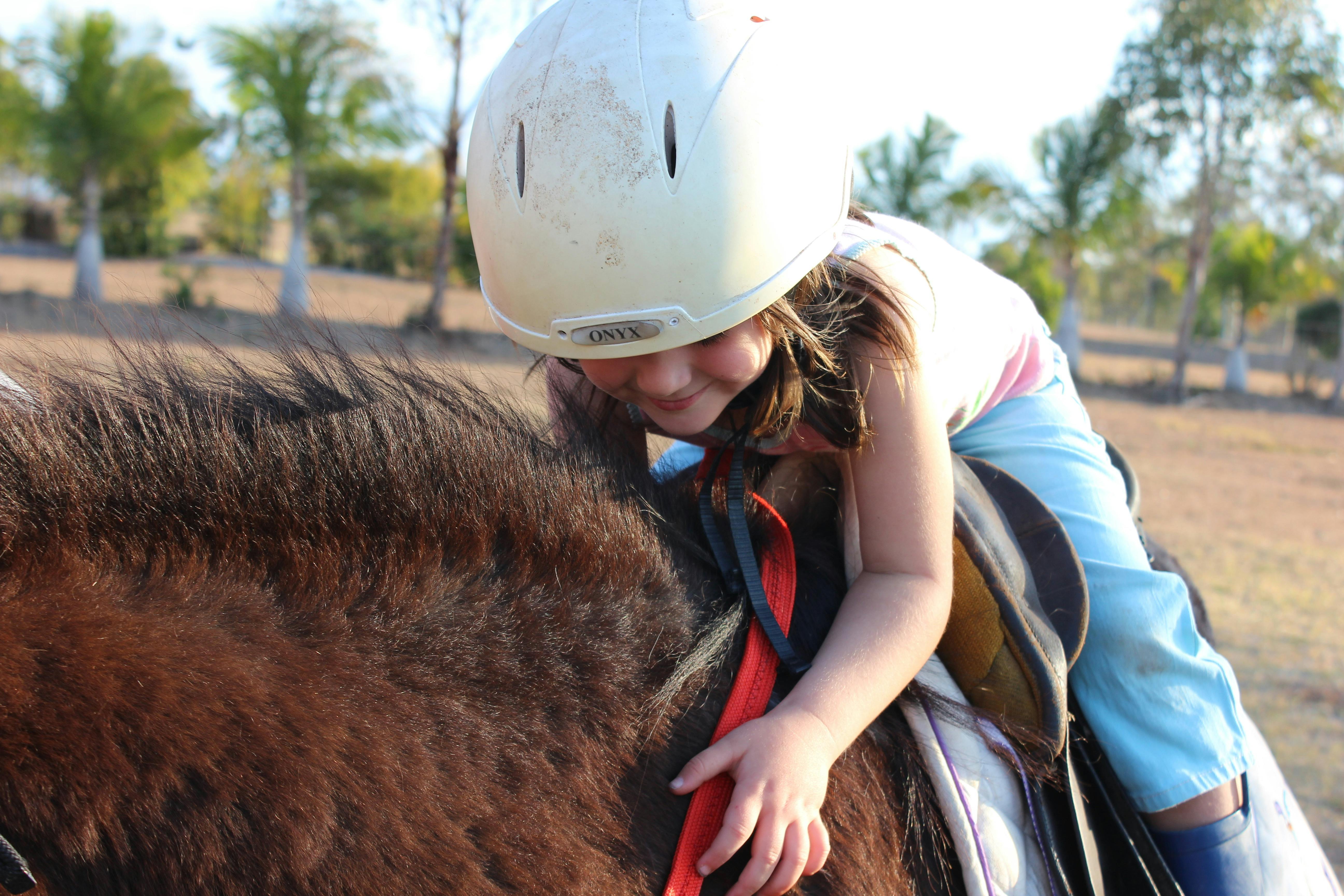 Kind umarmt liebevoll ein Pony